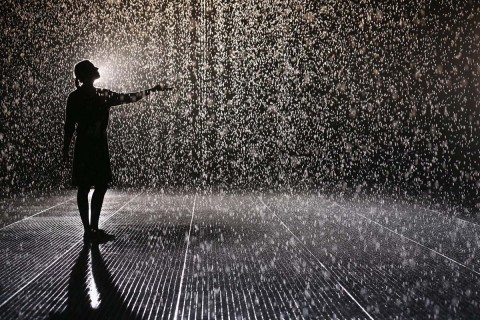 LONDON, ENGLAND - OCTOBER 03: A woman experiences the 'Rain Room' art installation by 'Random International' in The Curve at the Barbican Centre on October 3, 2012 in London, England. The 'Rain Room' is a 100 square meter field of falling water which visitors are invited to walk into with sensors detecting where the visitor are standing. The installation opens to the public on October 4, 2012 and runs until March 3, 2013. (Photo by Oli Scarff/Getty Images)