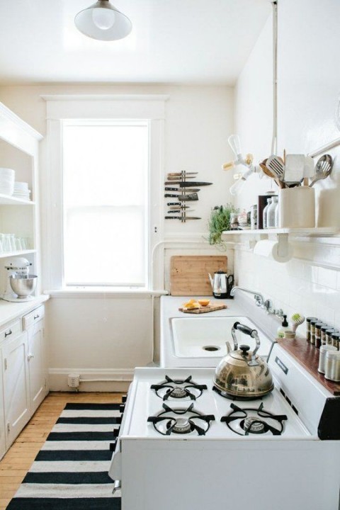 White kitchen with black and white rug and features - Photo found on thekitchn.com