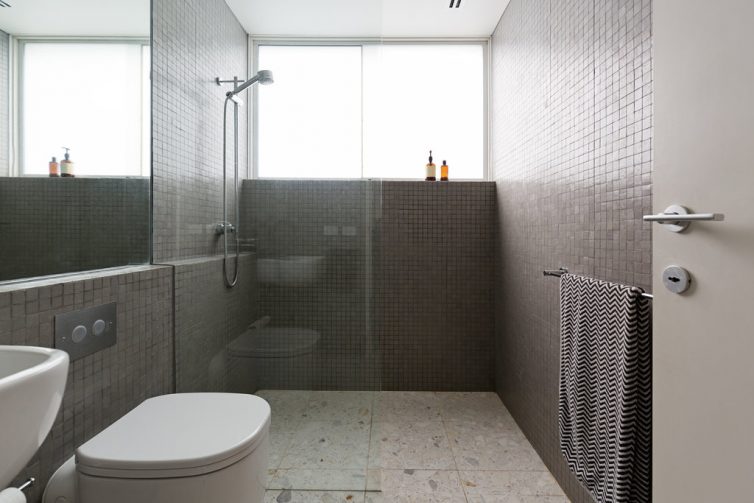 Modern walk in shower with mosaic full height tiles and terrazzo floor