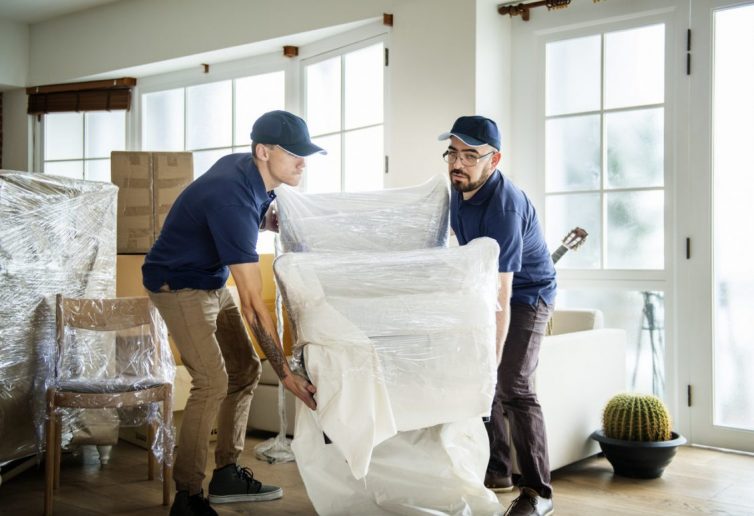 Two Men Lifting Chair. Removal Company.