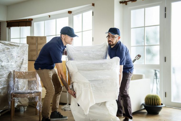 Two Men Lifting Chair. Removal Company.