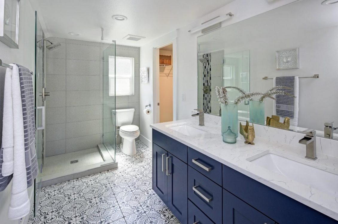 Bathroom with walk in shower and blue sink cabinets