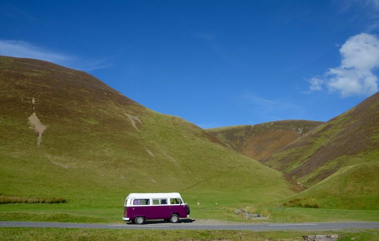 Purple VW camper van in the hills of Scotland