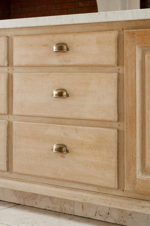 Tuscan inspired kitchen limestone plinth material. Light Oak kitchen draws with brass cup pull draw handles