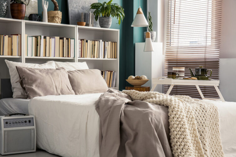 Small bedroom with book storage by bed