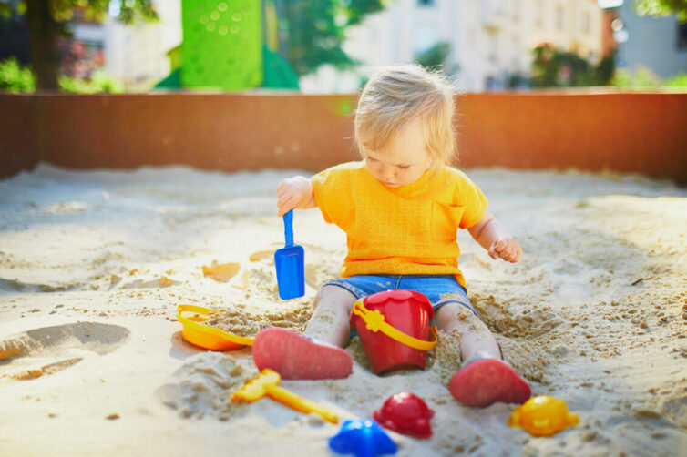 Young child playing in sandpit.