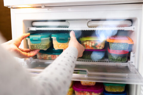 Frozen fruit and vegetables in pots in freezer.