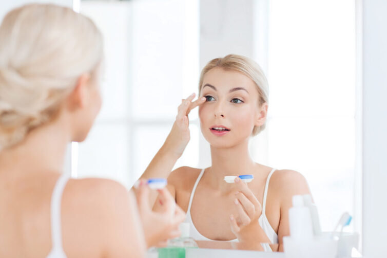 Young women putting contact lenses in