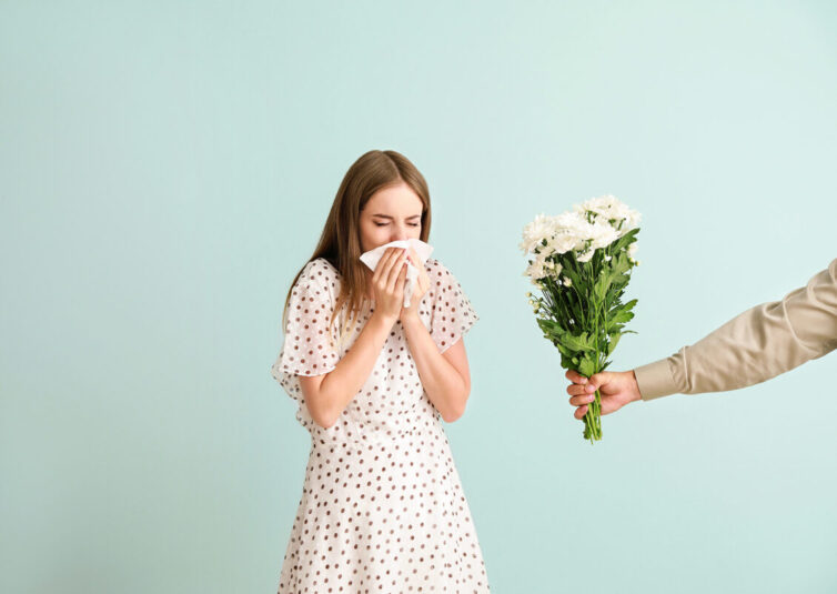 Women with allergies sneezing due to being given flowers