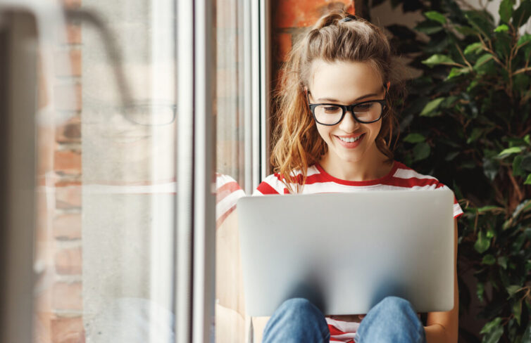 Women sat by window using laptop