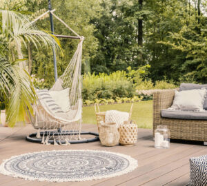 Hammock on patio with round rug and rattan sofa in the garden