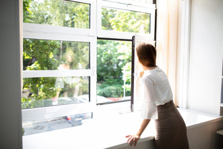 Business women looking out open office window