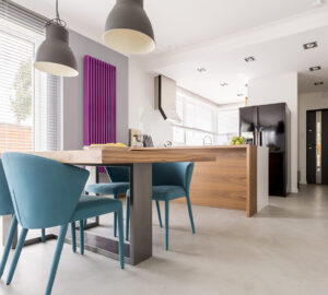 Purple radiator in contrast with white and wooden kitchen.