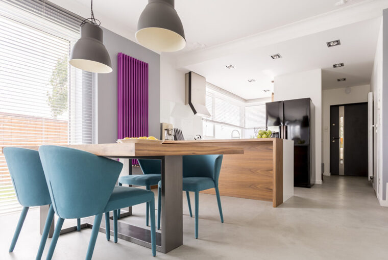 Purple radiator in contrast with white and wooden kitchen.