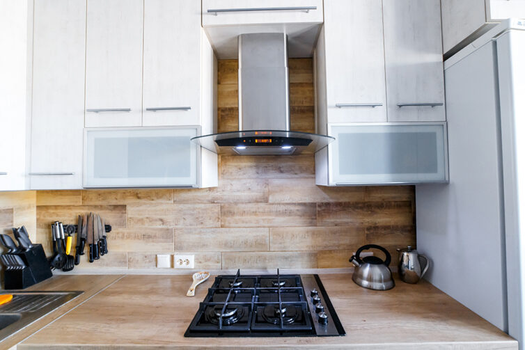 White kitchen cupboards with wooden worktops and wooden backsplash