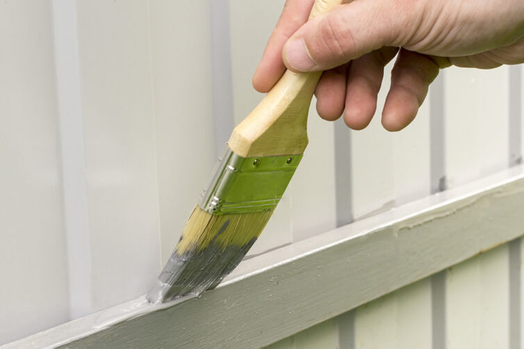 Repairing and painting wooden fence