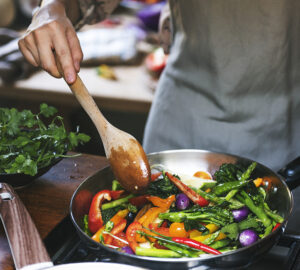 Woman cooking stir fried vegetables