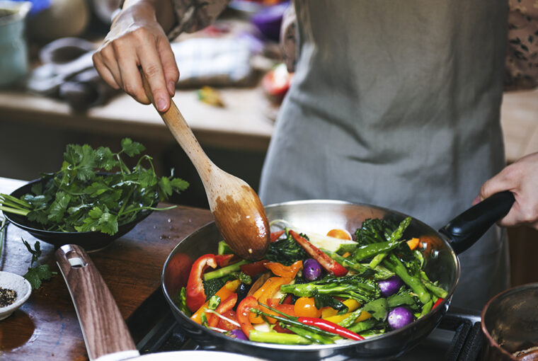 Woman cooking stir fried vegetables