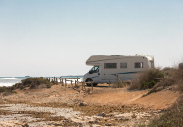 Campervan parked on the beach by the sea