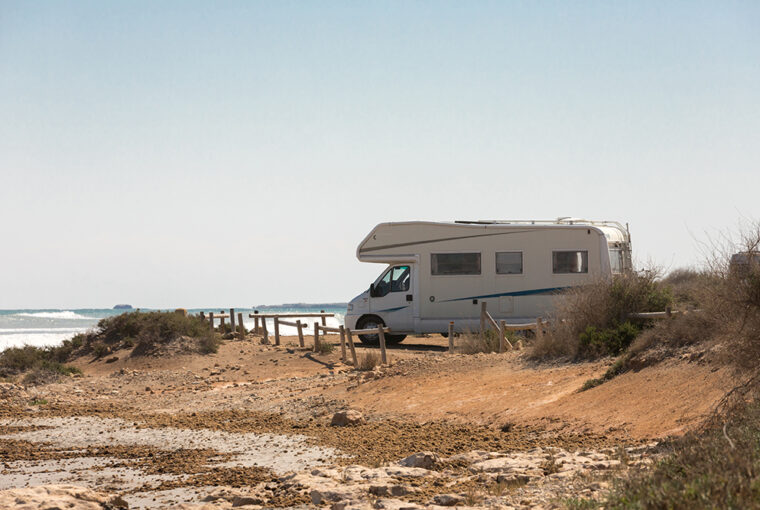 Campervan parked on the beach by the sea