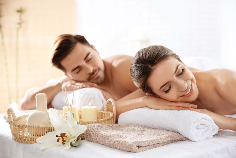 Young couple with spa essentials in wellness center