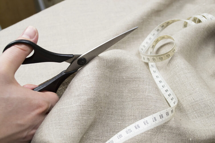 Scissors cutting linen fabric
