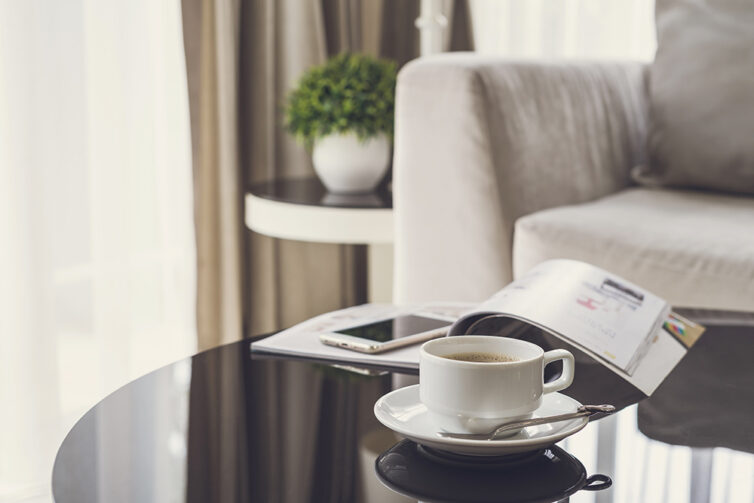 Black glass coffee table with cup and saucer.