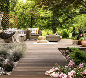 Wooden decking with wicker garden furniture. Surrounded by trees