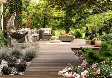 Wooden decking with wicker garden furniture. Surrounded by trees