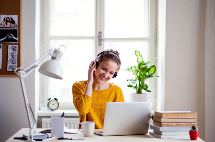 Women working and studying from home. Sat at desk with laptop.