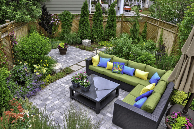 Garden with tiled patio, trees, shrubs and garden furniture