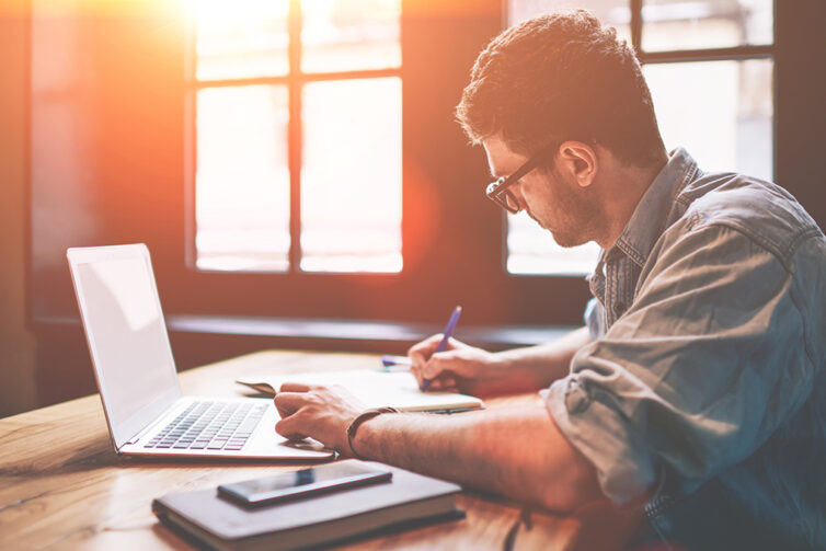 Man sat at desk using laptop