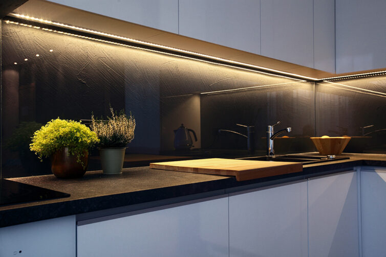 White kitchen cabinet with undercabinet LED strip lighting.