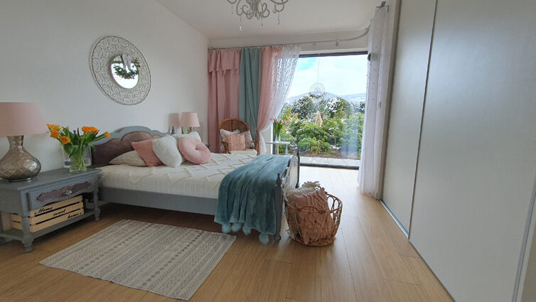 Large bedroom with large windows and view of trees