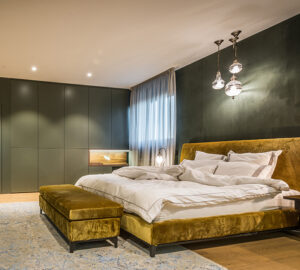 Green paintedd bedroom with gold bed. Large green built in wardrobes