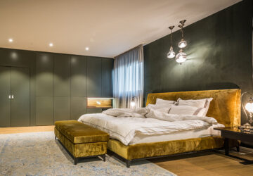 Green paintedd bedroom with gold bed. Large green built in wardrobes