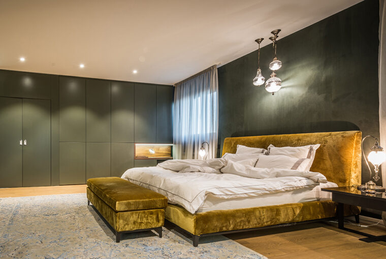 Green paintedd bedroom with gold bed. Large green built in wardrobes