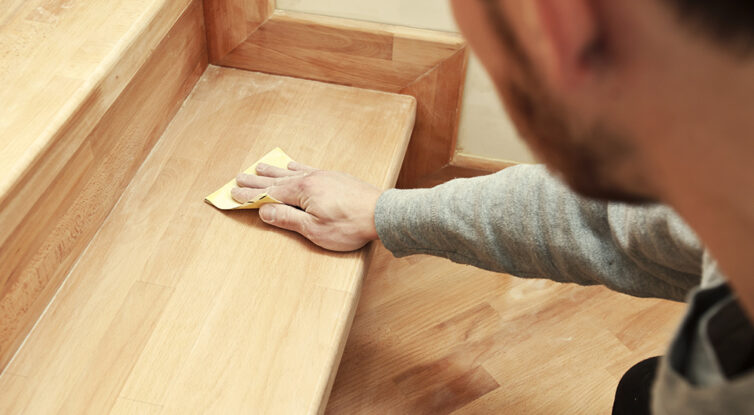 Sanding wood on staircase