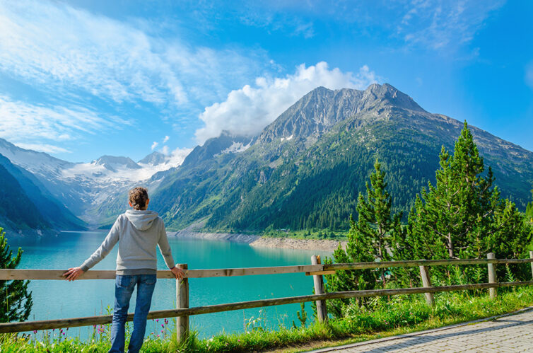 Women standing beside an azure mountain lake, Canada.