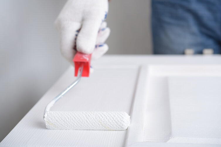 Painting door with white paint and a paint roller