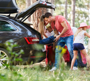 Family unpacking car on holiday