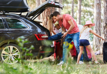 Family unpacking car on holiday