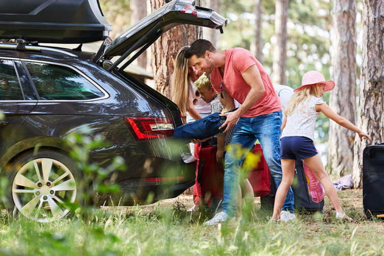 Family unpacking car on holiday