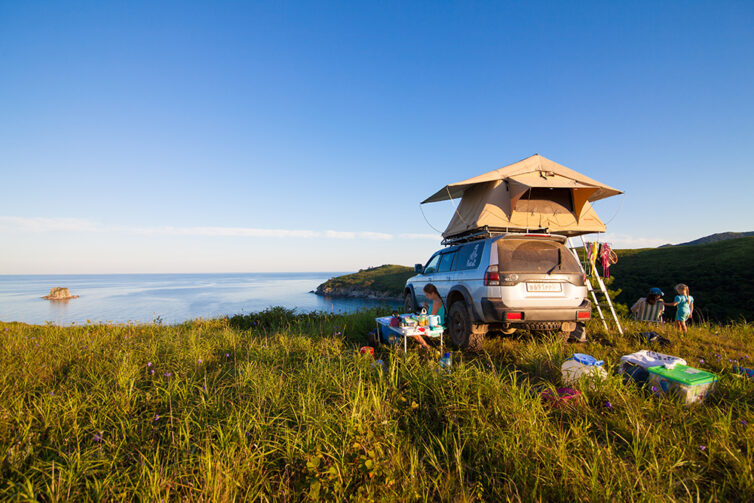 Car with roof top tent by the sea