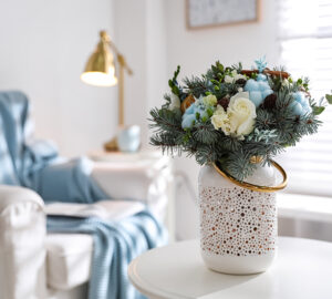 White vase with blue and white flowers placed on table in louge.