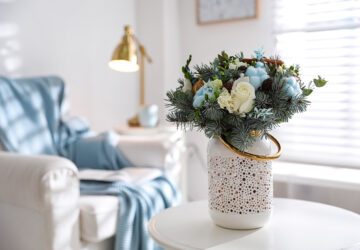 White vase with blue and white flowers placed on table in louge.