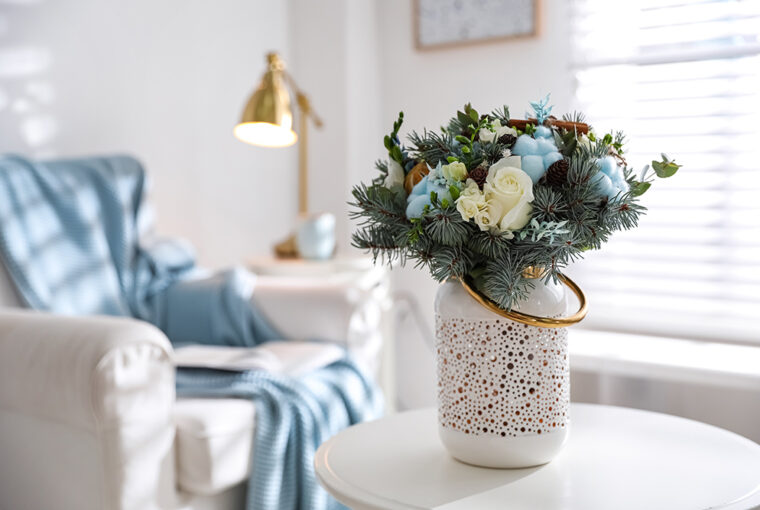 White vase with blue and white flowers placed on table in louge.