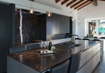 Modern stylish dark kitchen with black marble countertops