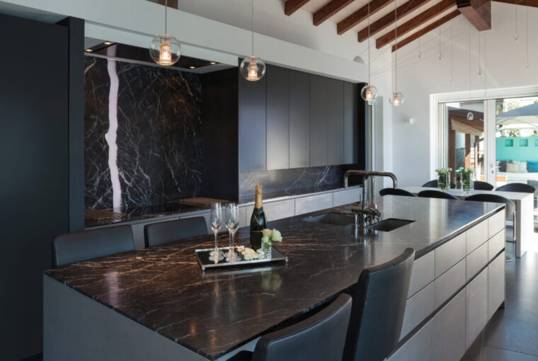 Modern stylish dark kitchen with black marble countertops