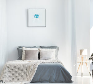 White and grey bedroom with wall art above the bed
